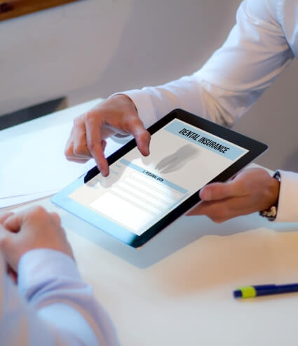 Two people looking at dental insurance form on a tablet
