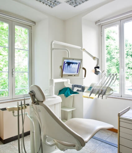 Dental treatment room with x rays of teeth on computer monitor