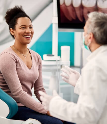 Woman in pink blouse smiling with her dentist