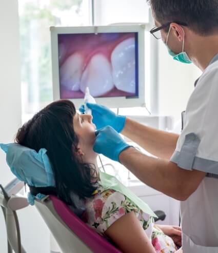 Dentist showing a patient images of her mouth on screen with advanced dental technology in Melbourne