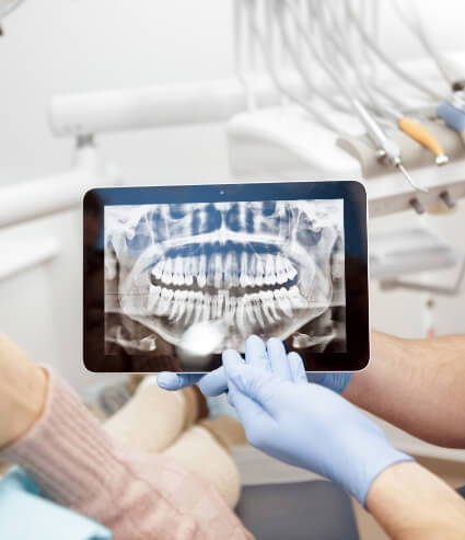 Dentist showing a patient their digital dental x rays on tablet screen