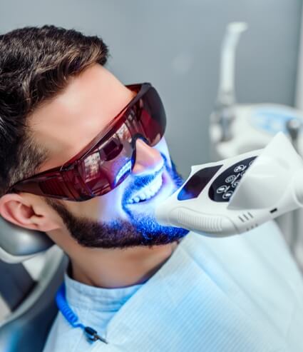 Man getting professional teeth whitening from cosmetic dentist