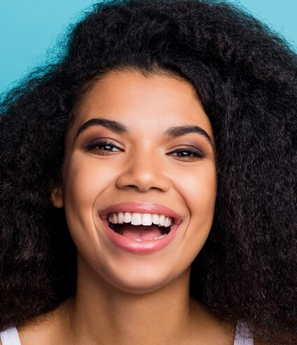 Woman with curly black hair grinning