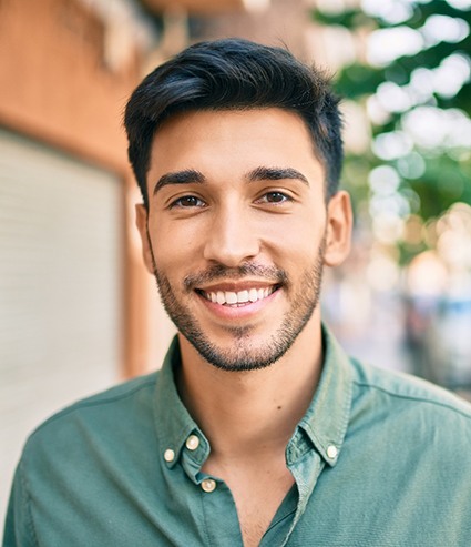 Smiling man walking down a busy city street