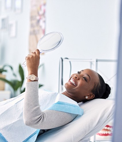 Woman smiling while looking at reflection in mirror