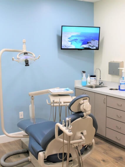Dental chair in light blue dental exam room