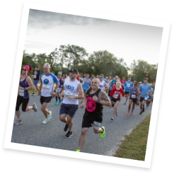 People smiling at the camera while running a race