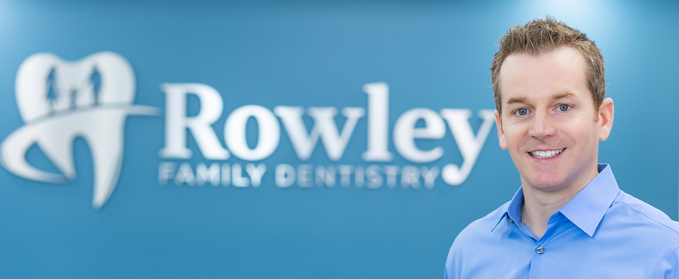 Melbourne Florida dentist Doctor Nicholas Rowley in front of Rowley Family Dentistry sign