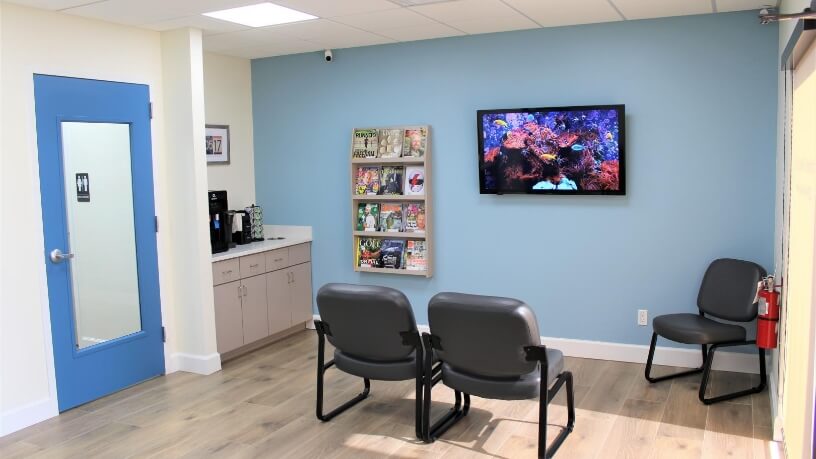 Chairs T V and refreshments in reception area of Rowley Family Dentistry