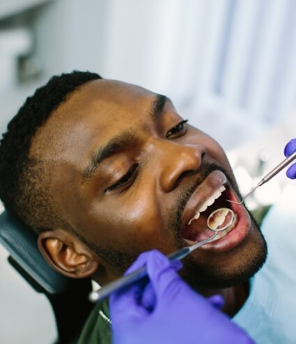 Man with dental mirrors in his mouth during oral cancer screening