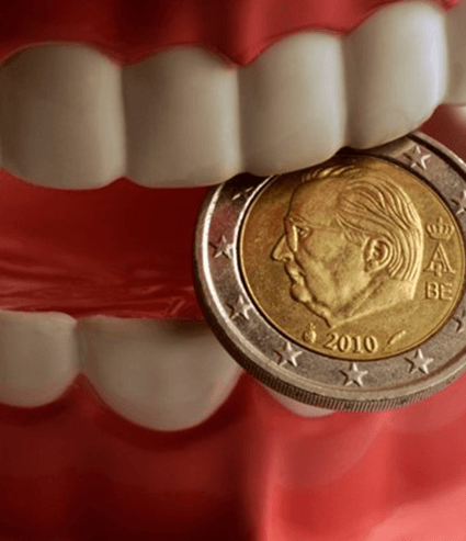 A model of dentures in Melbourne holding a coin