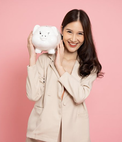 Woman holding a piggy bank over her shoulder and smiling