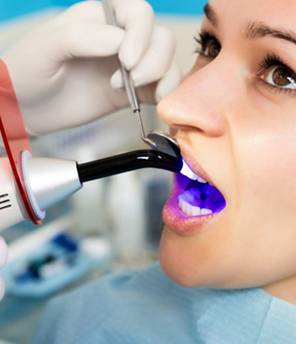 Dentist carefully whitening a patient’s teeth in-office