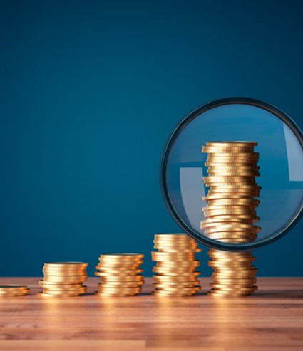 Magnifying glass examining a stack of coins