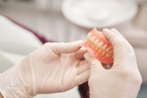 Dentist holding set of dentures.