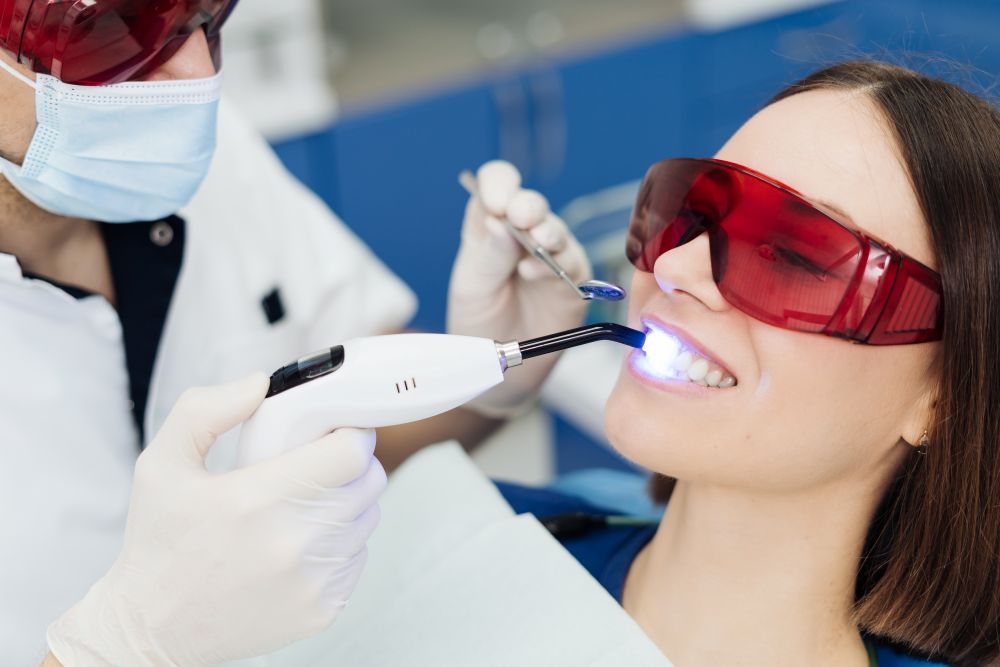 A woman getting her teeth whitened at her dentist’s office.